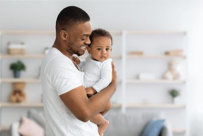 Father holding his baby at home