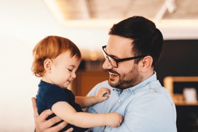 Father laughing with his toddler at home