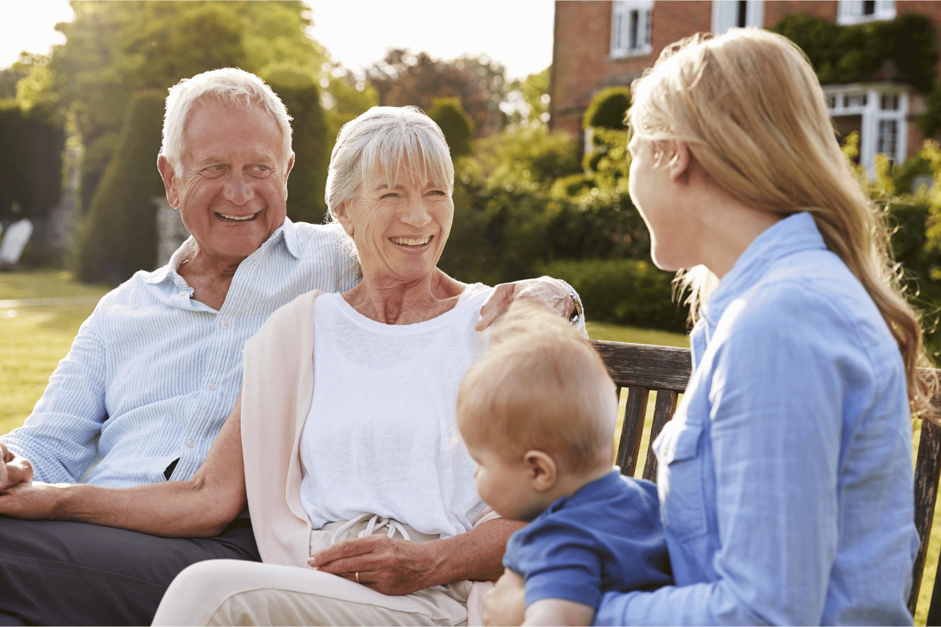 Grandparents sitting outdoors with their adult daughter and grandchild