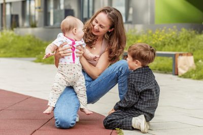 Mother playing outdoors with her two young children