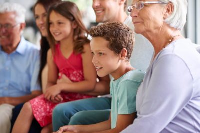 Multi-generational family sitting together and smiling