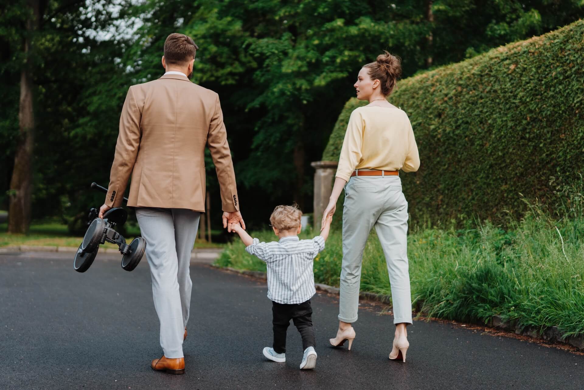 Young family walking together with their son in a park
